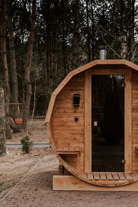 Sauna Beczka WarmEscape wśród sosen, przy ceglanej ścieżce