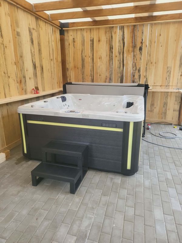 Jacuzzi Bartolomeo ze schodkami i podświetleniem LED pod drewnianym zadaszeniem, realizacja u klienta WarmEscape