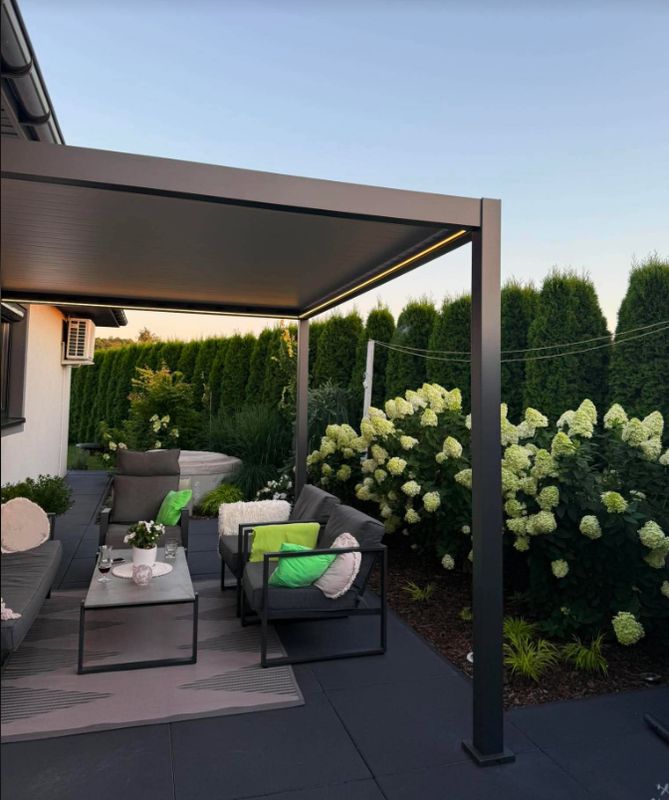 Pergola Kotoba nad tarasem z sofami ogrodowymi, obok hortensje