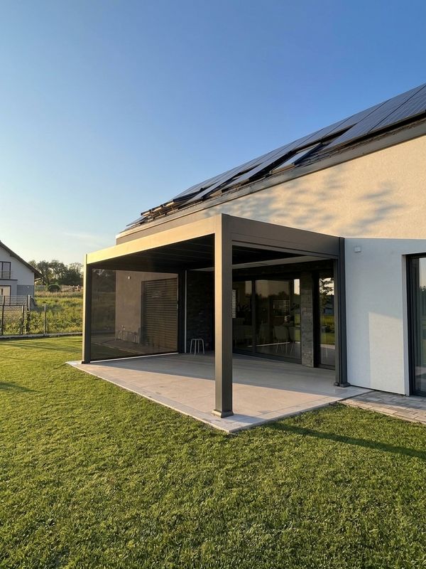 Pergola Kotoba przy nowoczesnym domu z panelami na dachu